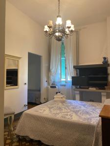 トッレ・デル・ラーゴ・プッチーニにあるCasa Simonettiのベッドルーム1室(シャンデリアとピアノ付きのベッド1台付)