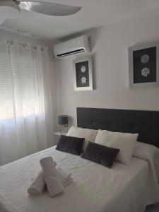 a bedroom with a white bed with two pillows on it at APARTAMENTOS MATUTE in Almodóvar del Río