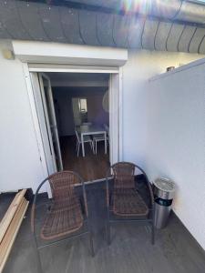 two chairs sitting on a balcony with a table at Cozy Apartment in Bad Vilbel in Bad Vilbel