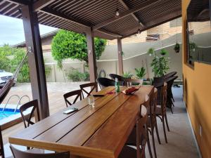 a wooden table and chairs on a patio at Casa Praia Frances 350m orla Q4 novíssima e superdecorada in Marechal Deodoro