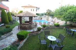 un patio trasero con mesa, sillas y piscina en Hotel Zeus, en Afitos