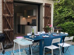 a blue table and chairs on a patio at Aux Couleurs Miel in Montolieu