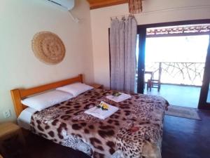 a bedroom with a leopard print bed with two plates on it at Paraíso da falésia em Cumuruxatiba com vista excepcional para o mar in Cumuruxatiba