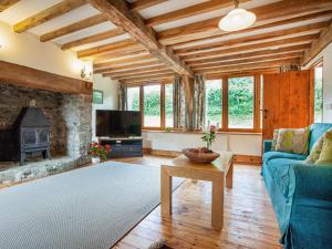 a living room with a blue couch and a fireplace at Pondmead in Monk Okehampton