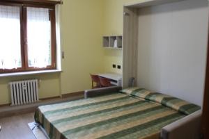 ein Schlafzimmer mit einem großen Bett in einem Zimmer in der Unterkunft Residence La Noce con Angolo Cottura in Chivasso