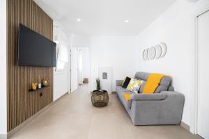 ein Wohnzimmer mit Couch und Flachbildfernseher in der Unterkunft Meraki3-Picina cubierta climatizada in Chiclana de la Frontera