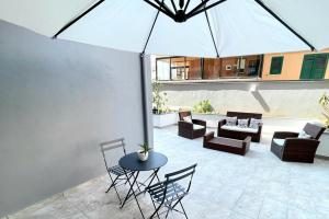a patio with a table and chairs and an umbrella at Perle di Sicilia in Milazzo