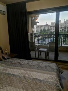 Schlafzimmer mit einem Bett und Blick auf einen Balkon in der Unterkunft Апартамент Релакс in Goldstrand