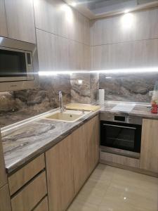 eine Küche mit einer Spüle und einer Mikrowelle in der Unterkunft Апартамент Релакс in Goldstrand