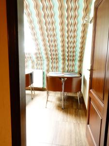 a table and chairs in a room with a wall at Villa Bartek in Tylicz