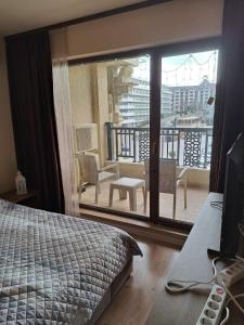 1 dormitorio con cama y vistas a un balcón en Апартамент Релакс, en Golden Sands