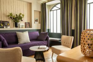een woonkamer met een paarse bank en stoelen bij Hôtel Elysées Régencia in Parijs