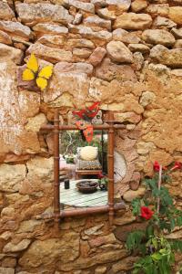 un alimentateur d'oiseaux sur un mur de pierre avec des papillons sur lui dans l'établissement La Maisonnette de La Jolie Vie, à Urval