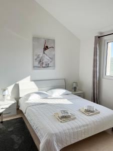 a white bedroom with a bed with two towels on it at Villa Pari Apartment in Kotor