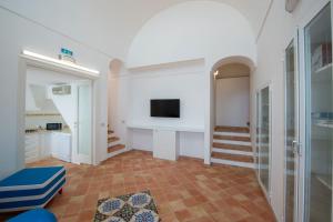 sala de estar con TV y escalera en Villa Mena, en Praiano