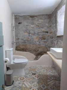 a bathroom with a white toilet and a sink at Ano Syros Marvellous oven in Ano Syros