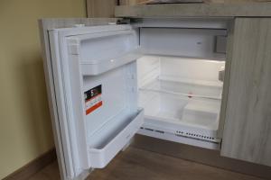 um frigorífico vazio com a porta aberta numa cozinha em Residence La Noce con Angolo Cottura em Chivasso