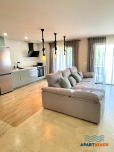 a living room with a couch and a kitchen at APARTBEACH SANCHO ABARCA CENTRICO y JUNTO PLAYA in Salou