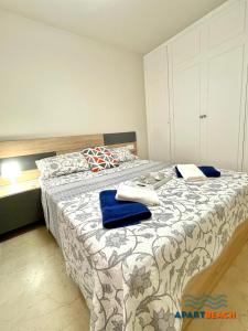 1 dormitorio con 1 cama grande y toallas azules. en APARTBEACH SANCHO ABARCA CENTRICO y JUNTO PLAYA en Salou