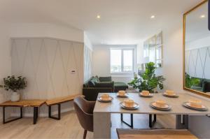 a living room with a table with plates on it at Light Airy Double Short walk from Elizabeth Line in Goodmayes