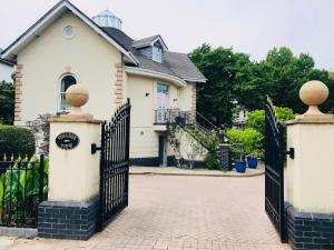 a white house with a black gate and a driveway at College View in Cheltenham