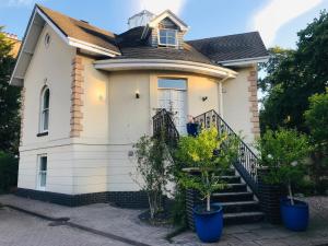 切尔滕纳姆校园美景住宿加早餐旅馆的前面有树木的小白色房子