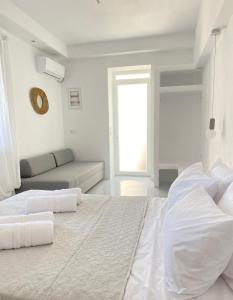 1 dormitorio blanco con 1 cama grande y 1 sofá en 31 Seafront Apartment, en Kampos