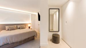 sypialnia z łóżkiem i lustrem w obiekcie Castillo San Carlos Luxury Apartments w mieście Torremolinos
