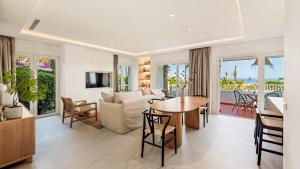 Castillo San Carlos Luxury Apartments في توريمولينوس: غرفة معيشة مع أريكة وطاولة