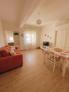 uma sala de estar com uma mesa e um sofá em Appartamento Corallo Rosso e Stella Blu em Belvedere Marittimo