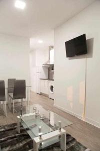 a living room with a glass table and a tv on a wall at Comodo Y Agradable Apartamento En Madrid Centro 2 in Madrid