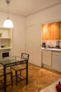 a kitchen with a table and chairs in a room at Un Elegante Piso Para Descubrir Madrid in Madrid