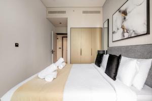 um quarto com uma grande cama branca com almofadas pretas em Downtown Ultra Luxury 1BR - 15 Northside - Burj Khalifa View no Dubai