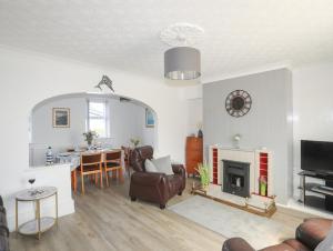 a living room with a fireplace and a table at Morlais Voice of the Sea in Aberffraw