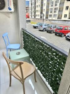 una silla y una mesa en un balcón con aparcamiento en Skopje Apartments near central Bus Station JK APARTMENTS, en Skopje