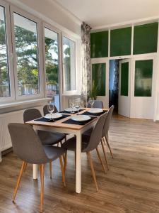 a dining room with a table with chairs and windows at Bella Rossi in Jastrzębia Góra