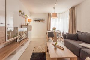 a living room with a couch and a table at Villa Manatee mit Sauna & Fitness in Ostseebad Sellin