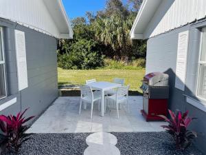 a patio with a table and chairs and a grill at Sunset Inn in Port Charlotte