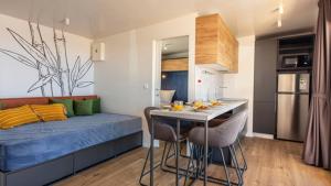 una camera con letto e una cucina con tavolo di Terra Park SpiritoS - Luxury mobile house Ina a Kolan