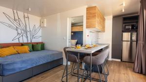 a room with a bed and a kitchen with a table at Terra Park SpiritoS - Luxury mobile house Ina in Kolan +23 photos