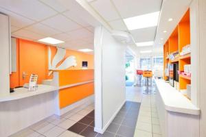 un bureau avec des murs orange et blancs et un couloir dans l'établissement Premiere Classe Tours Sud - Joue Les Tours, à Joué-lès-Tours