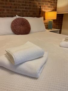 a bed with white towels on top of it at Rock Studio -Near City Centre-Free on street Parking-Free Wi-Fi in Leeds