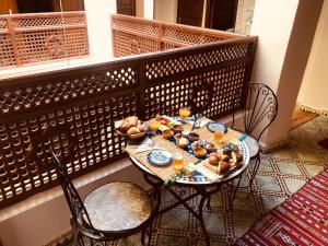 una mesa con comida y bebida en el balcón en famille fahym en Fez