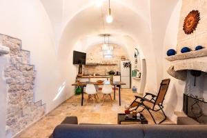 - un salon avec une table et des chaises dans l'établissement Trullo Nonno Vittorio, à Latiano