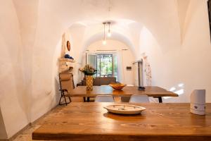 une salle à manger avec une table en bois et une table à manger dans l'établissement Trullo Nonno Vittorio, à Latiano