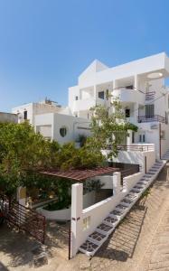 a large white building with trees in front of it at Markakis Apartments in Elounda