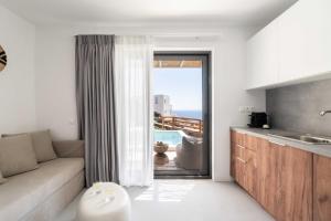 een woonkamer met een bank en uitzicht op de oceaan bij Aura Villas Tinos in Agios Romanos