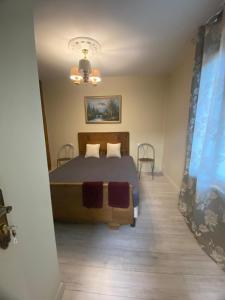 a bedroom with a bed and a table and chairs at Leleka Apartment 9 in Esbly