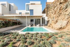 a villa with a swimming pool in the desert at Aura Villas Tinos in Agios Romanos