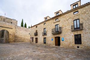 un gran edificio de ladrillo con un patio delante de él en YIT La Casona del Arco en Baeza